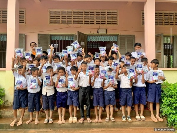 사진 설명/아이들이 위생키트를 들고 환하게 웃고 있다.