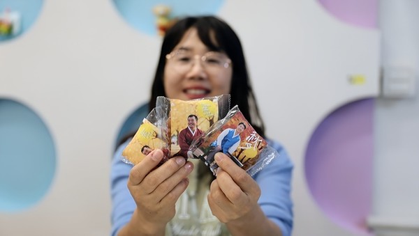 사진 설명/서울장애인종합복지관이 AI 기술로 발달장애인에게 특별한 한복 사진을 선물했다. 사진을 부착한 약과 선물을 받은 복지관 직원이 활짝 웃고 있다.